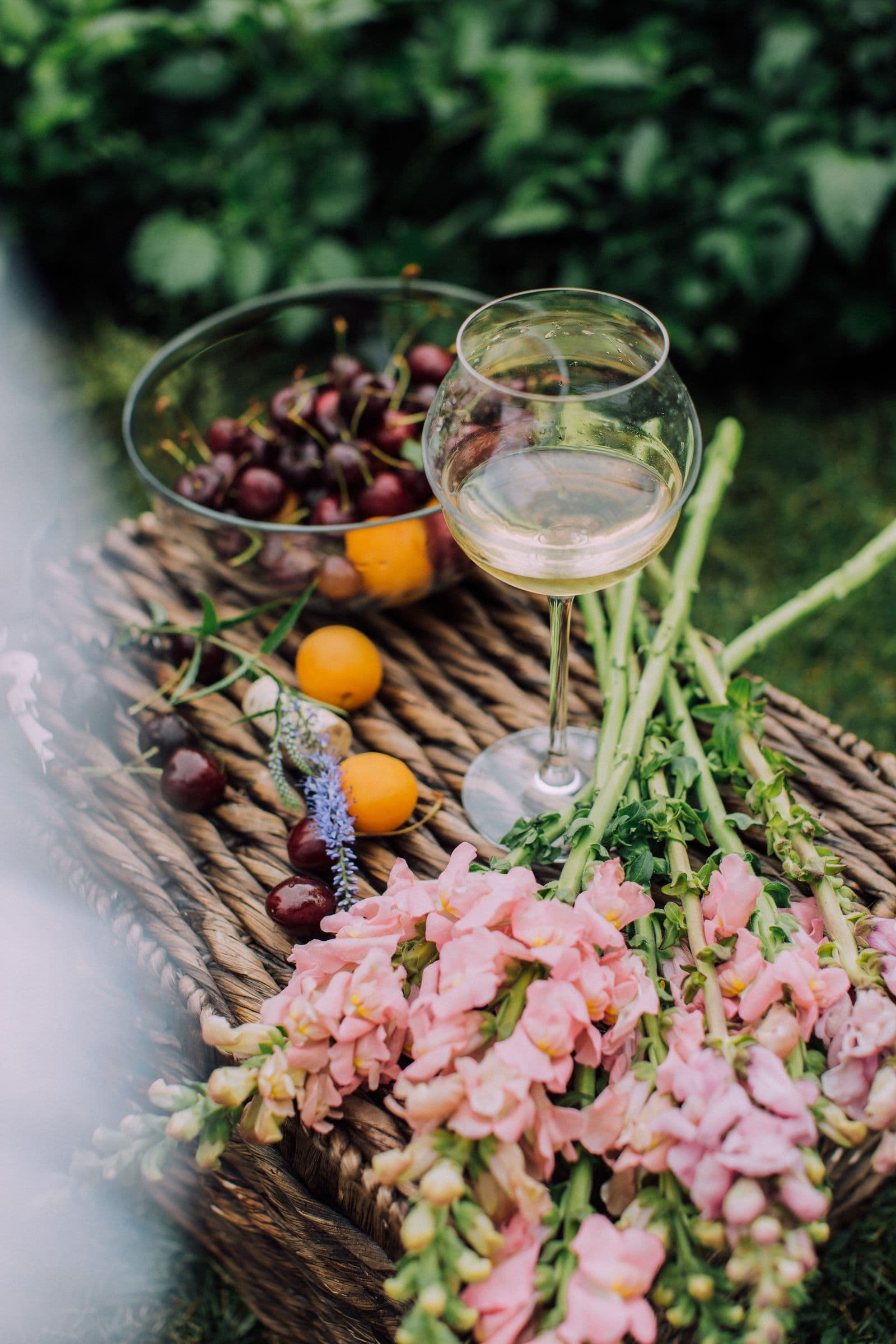 Cesta de bienvenida con vino, fruta y flores a la entrada de una villa